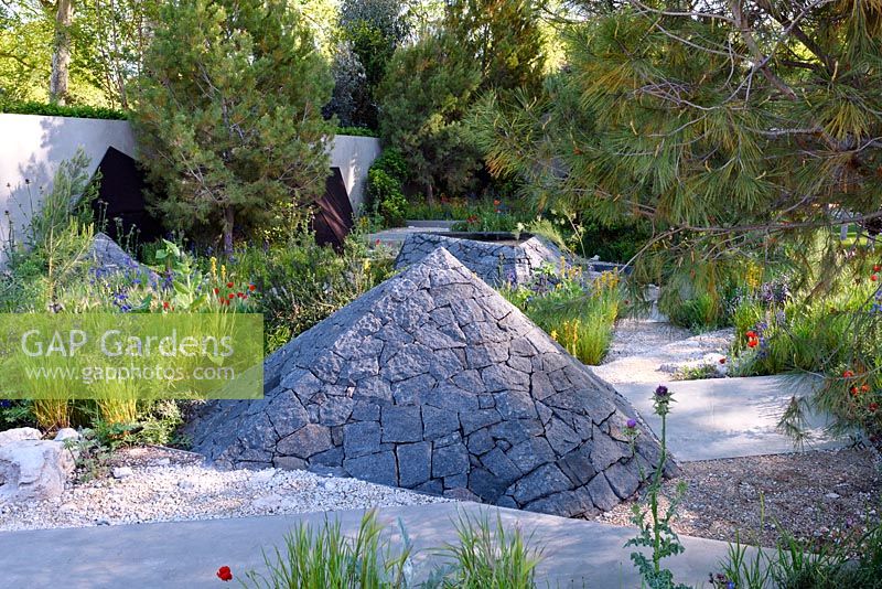 Royal bank Of Canada Garden. Multi-faceted basalt sculptures in Mediterranean style garden. The RHS Chelsea Flower Show 2016. Designer: Hugo Bugg, Sponsor: The Royal Bank of Canada