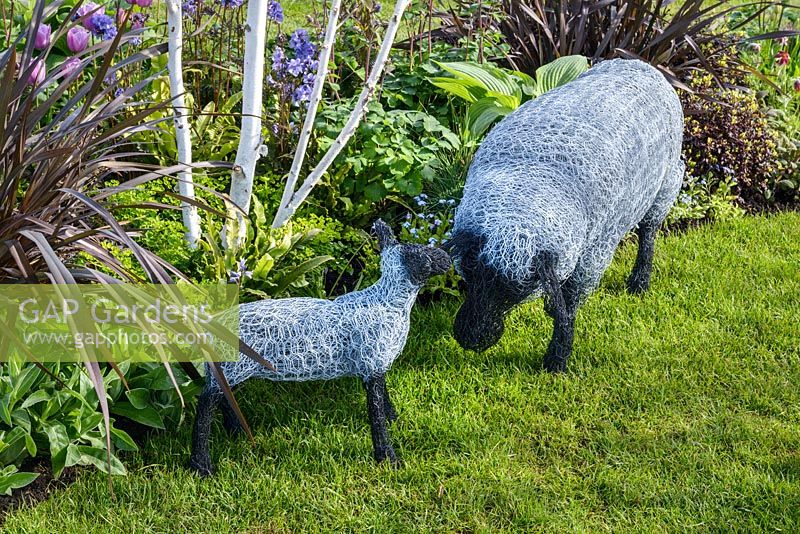 Wire sheep sculptures in front of Betula utilis var Jacquemontii and Phormium 'Platt's Black' - Hidden Gems of Worcestershire, RHS Malvern Spring Festival 2016 . Design: Nikki Hollier. Silver, Best Festival Garden