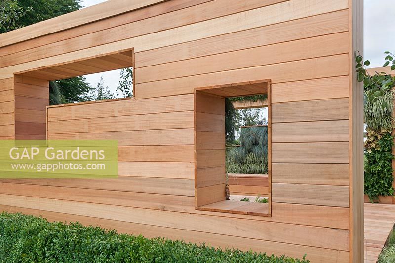 Wooden slatted outdoor room construction with window recesses and views to vertical wall planting. The Green Room, RHS Tatton Flower Show 2011, Cheshire

