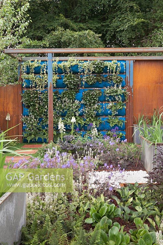 A contemporary corten steel construction with living wall and large metal rectangular containers. Rider on the Storm, RHS Tatton Flower Show 2011, Cheshire