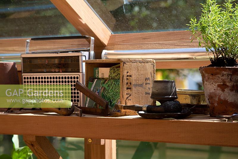 The inside of a relaxed greenhouse. Seeds in boxes, an old radio and various tools