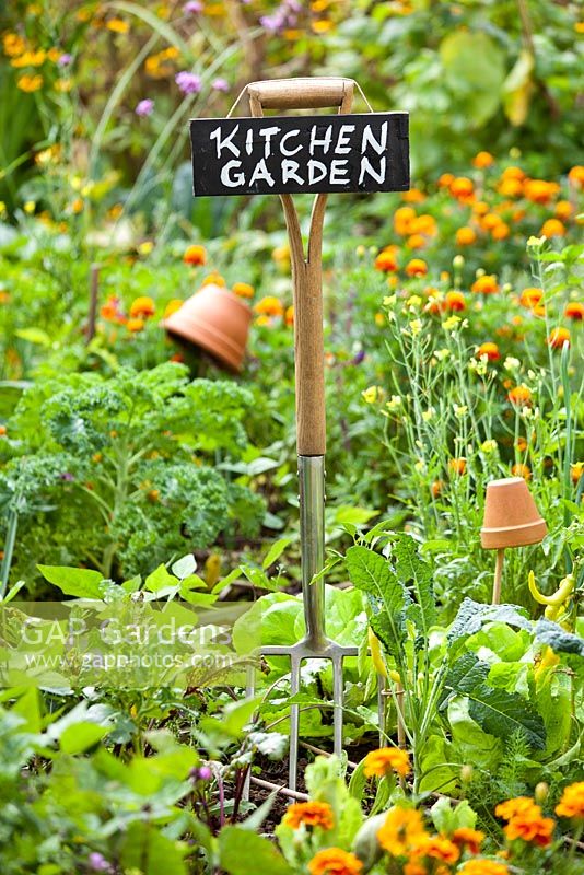 Garden fork with hanging sign.