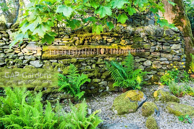 'Going by Sleeper'. Wood and stone artwork inserted into drystone wall.