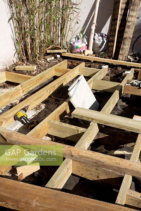 Fixing joists before laying decking in small urban garden