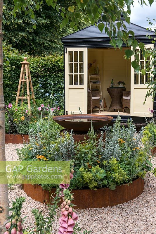 An Arts and Crafts inspired garden with a circular theme, raised corten steel borders, water feature and summerhouse. A Summer Retreat designed by Laura Arison and Amanda Waring. Hampton court flower show 2016 