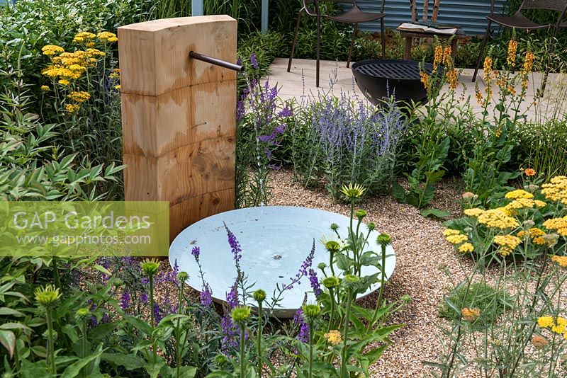 A water feature in a gravel bed planted with Echinacea, perovskia, Achillea and veronicastrum. A Retreat Garden designed by Martin Royer. Hampton court flower show 2016