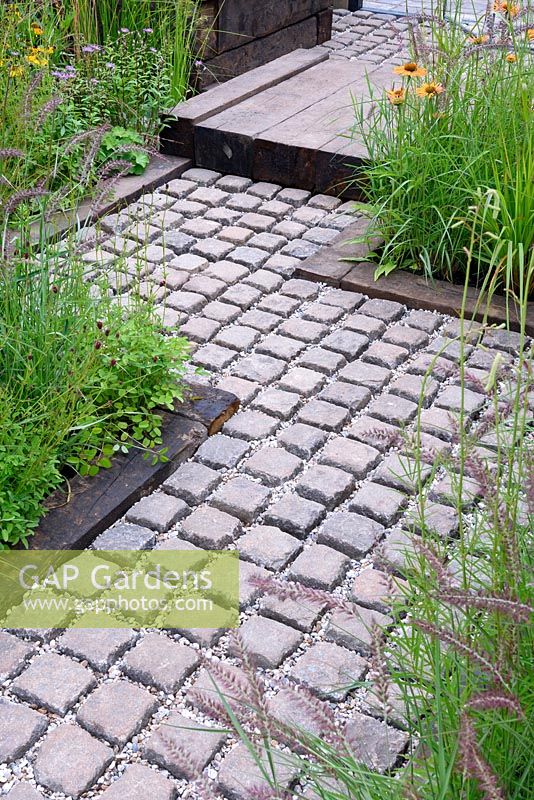 Fancy A Brew. Take A Pew. Cobbled stone path edged with sleepers. Designer: Lee Burkhill. RHS Hampton Court Palace Flower Show 2016

