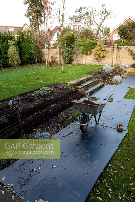 Construction of stepped border in London garden - the first foundation trenches being dug
