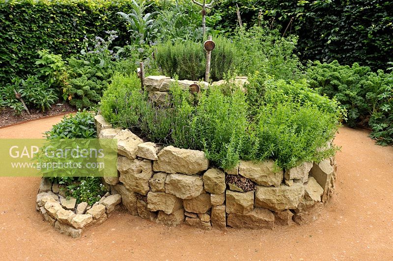 Herb spiral made of stones with Satureja montana, Lavandula angustifolia, Mentha x piperita, Rosmarinus officinalis and Origanum vulgare. 'Le jardin qui se savoure' designed by Guillaume Popineau, David Trigolet and Chantal Dufour at the Festival International des Jardins 2016, Chaumont-sur-Loire, France