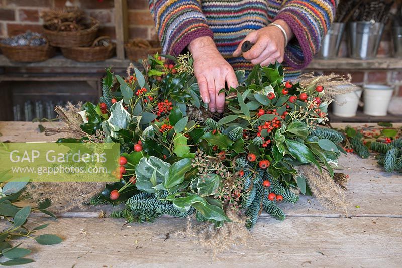 Adding Ilex aquifolium to the wreath