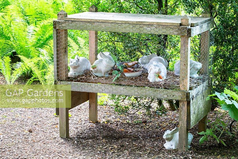Decorative white porcelain rabbits in a wood cage
