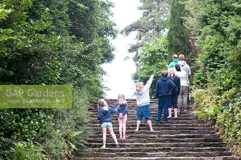 Visitors gather for a selfie on stone steps  in the Gardens of Ilnacullin - Garinish Island. Glengarriff, West Cork, Ireland. August