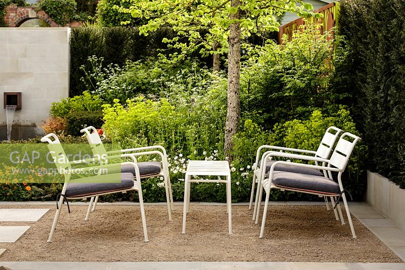 Contemporary white metal garden furniture on compacted gravel - Graduate Gardeners 'Sunken Retreat' Garden - RHS Malvern Spring Show 2016. Designer: Ann Walker