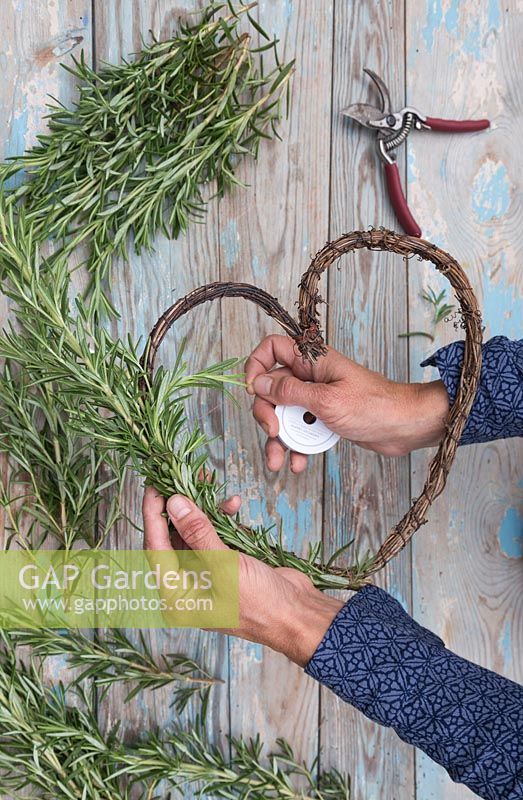 Tying Rosemary around wreath with string