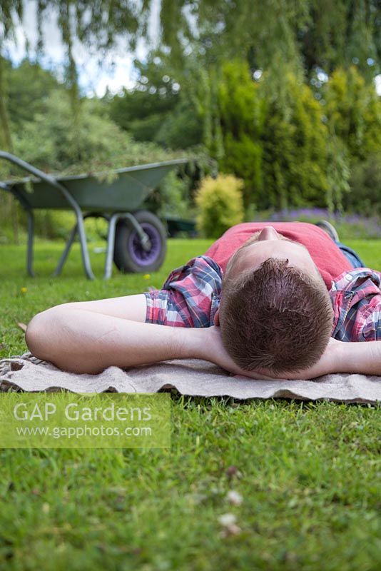 Man laying on a rug in the garden relaxing