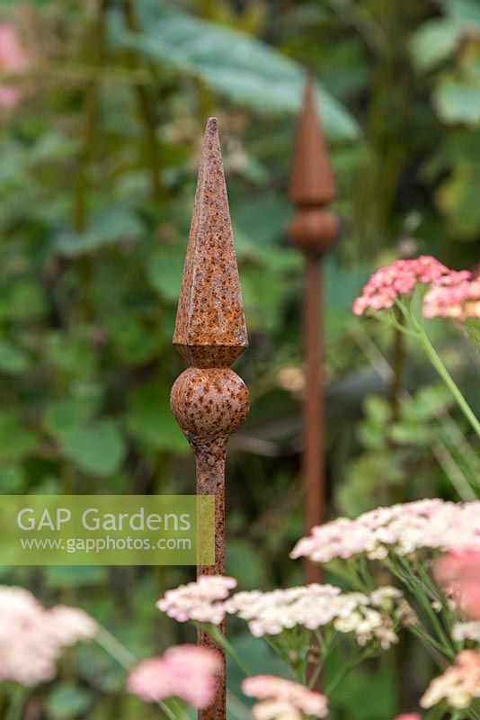 One of Roger Cole-Jones' hand crafted plant supports in a border with Achillea