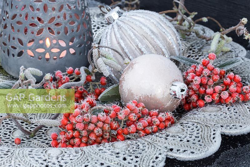 Silver platter containing frosted baubles, Cotoneaster berries and Corylus avellana branch