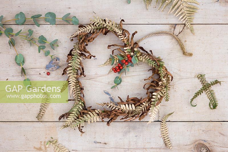 A wreath made with gold spray painted Fern foliage, dead fern foliage, Eucalyptus and Ilex verticillata