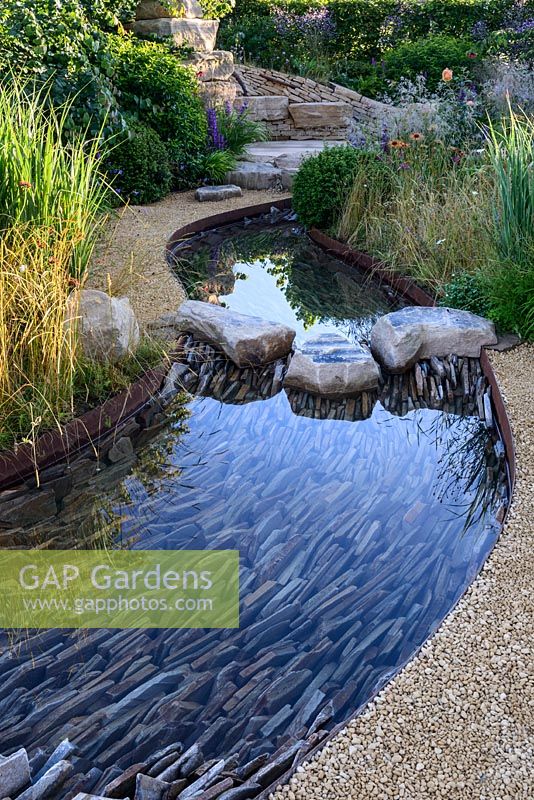 Rock stepping stones over a water rill, Cercidiphyllum japonicum with Prunus lusitanica and Panicum virgatum 'Northwind' - Zoflora: Outstanding Natural Beauty, RHS Hampton Court Palace Flower Show 2016