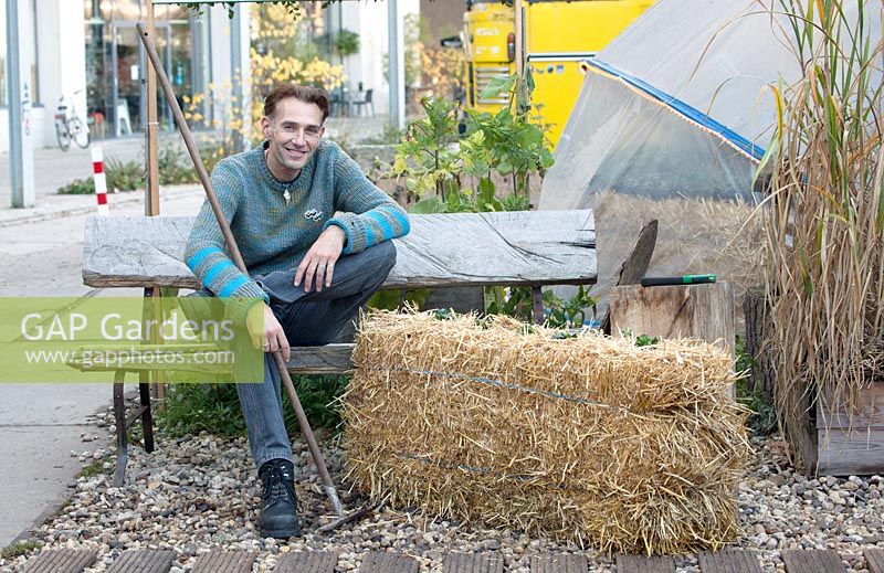The dutch designer Paul van Hedel sitting on a straw bale.