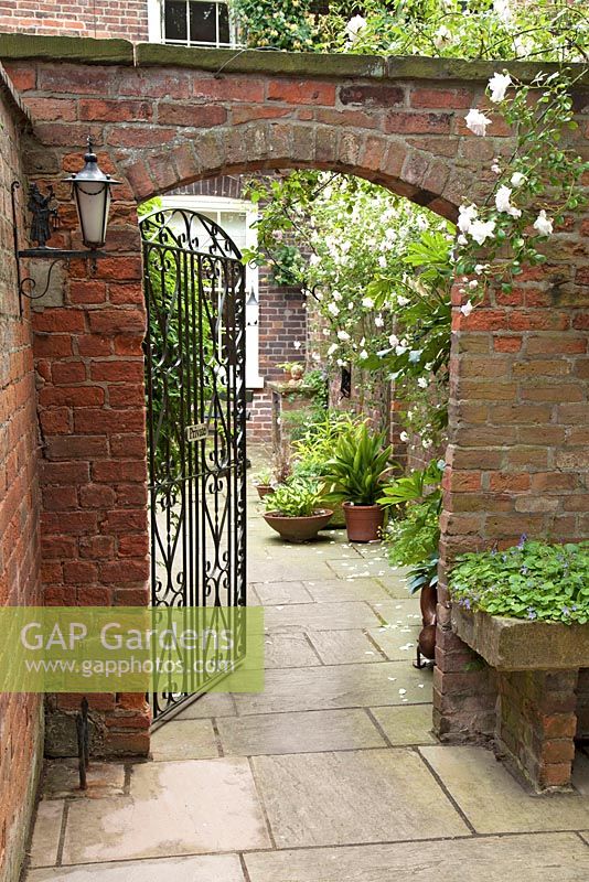 Brick archway through to small courtyard at Bolham Manor, Nottinghamshire in June