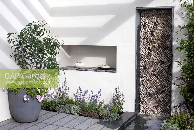 An Urban Retreat Garden, BBC Gardener's World Live 2016, patio area with pebble wall feature