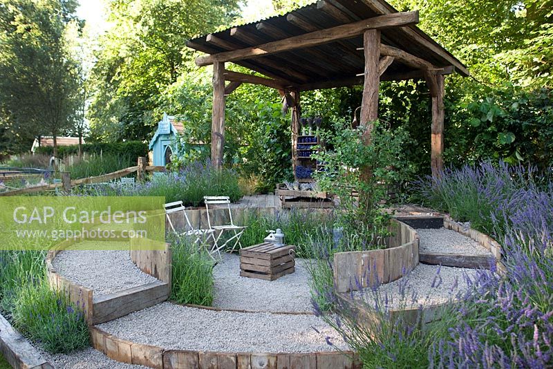 Seating area surrounded by raised path and lavender in the The Lavender Garden at RHS Hampton Court Flower Show 2016