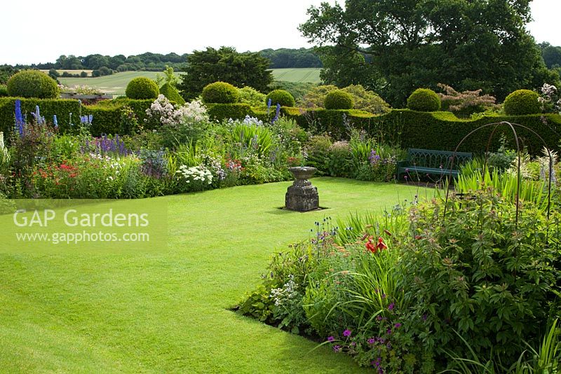 Perennial flower borders and topiary at Felley Priory gardens in Nottinghamshire in July