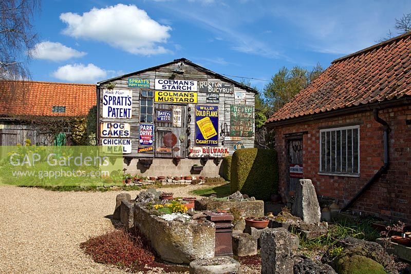 An old barn decorated with vintage advertising signs at Cliff and Joan Curtis's garden, Chapel Street Bourne, Lincolnshire
