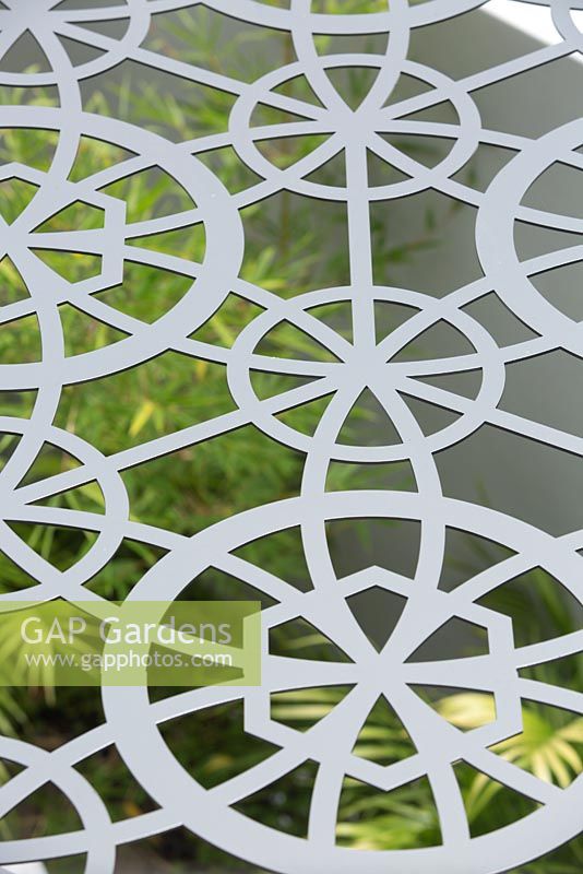 Detail of a metal laser cut pergola roof with a geometric pattern.