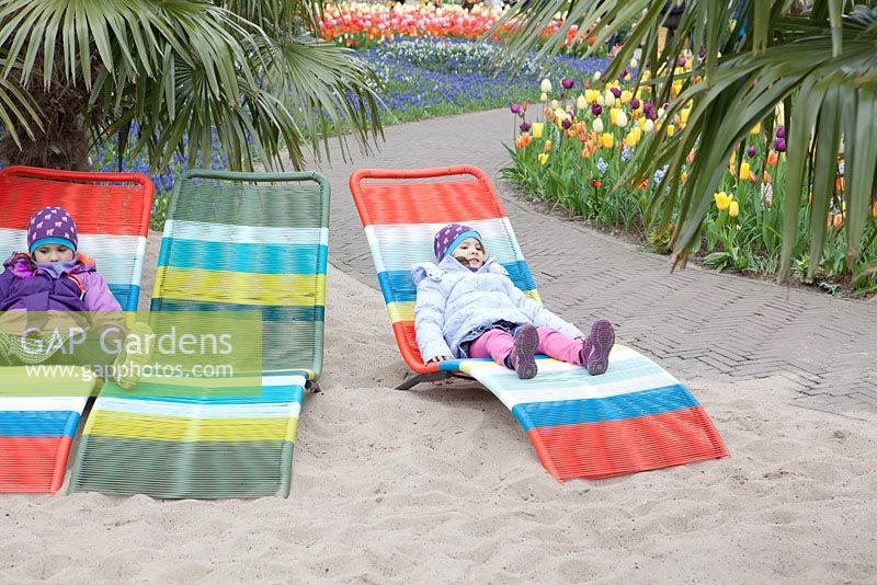 Children lounging on the colourful beach chairs. Beach-inspiration garden at Keukenhof 2017.