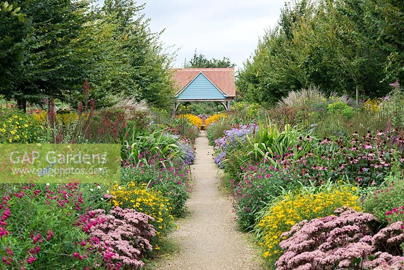 68-metre-long twin herbaceous borders, named 'The Jubilee Walk', backed by hornbeam, and planted with penstemon, salvias, sedum, coreopsis, Lobelia tupa, coneflowers, asters, miscanthus, helianthus and rudbeckias.