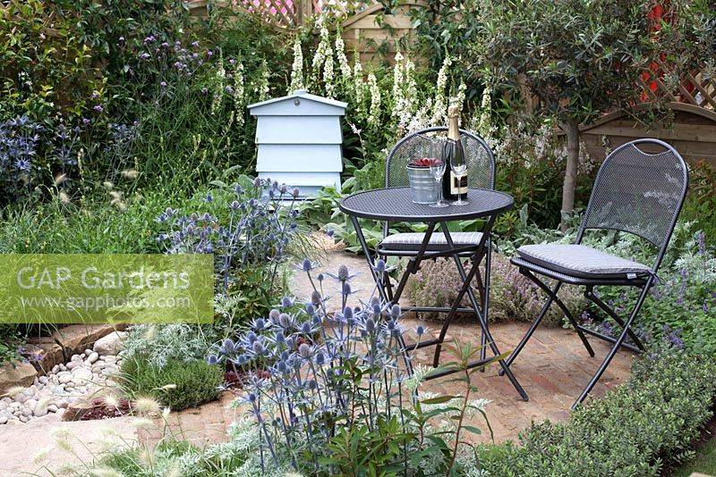 Seating area and beehive in The Drought Garden at RHS Hampton Court Palace Flower Show 2016