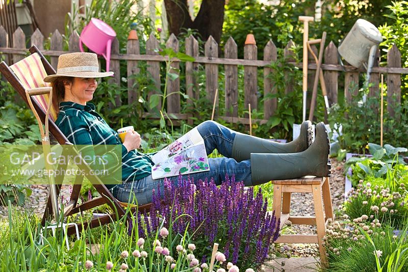 Woman relaxing in kitchen garden.