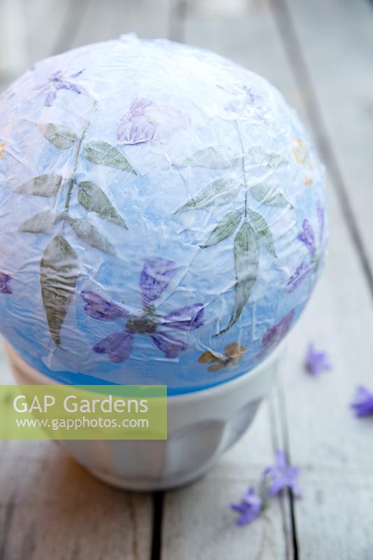 Making paper lanterns - Once you have finished applying the flowers put a final layer of tissue paper all over the flower lantern and leave to dry thoroughly. Pop balloon and peel away from bowl. Thread with wire if you are going to hang it.