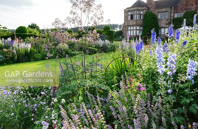 Herbaceous borders in front of the house include scabious, thalictrum, delphiniums, salvias and achilleas. Felley Priory, Underwood, Notts, UK