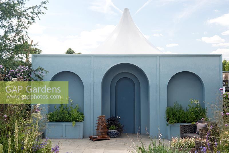 Mediterranean style garden with paved area and blue arched wall - Viking Cruises World of Discovery Garden, RHS Hampton Court Palace Flower Show 2017