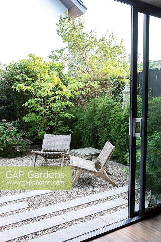 Gravel garden with lounge chairs. Planted with bamboo, Aralia and Hydrangea