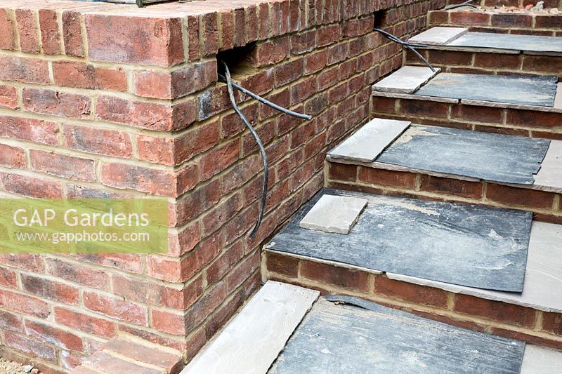 Steps with new paving with builders protective covering in urban garden