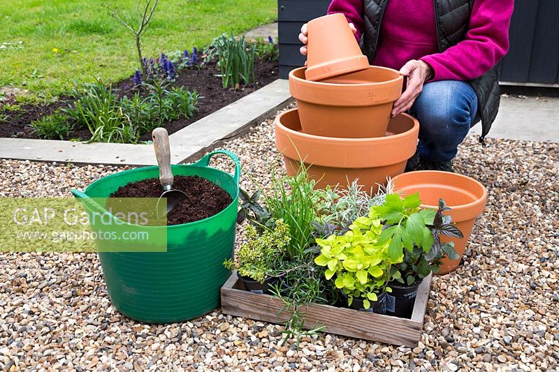 Placing small container inside pots to create a level for the tiered containers