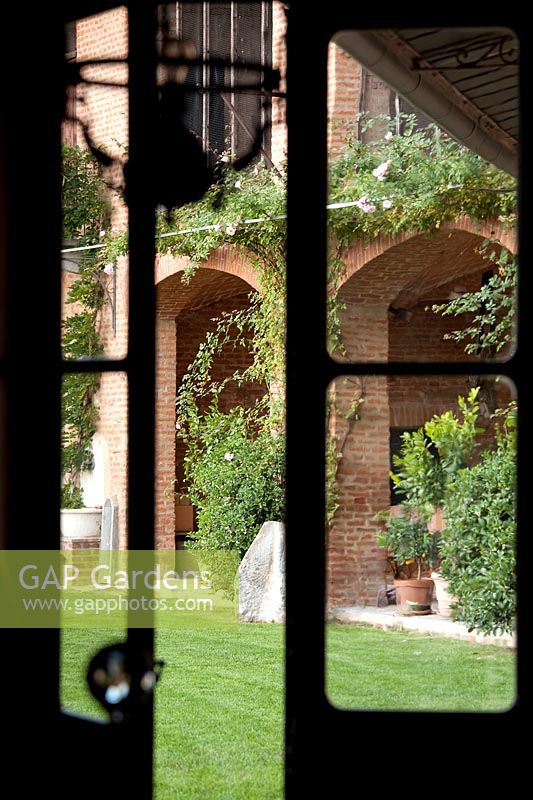 Garden viewed through french doors. Govone. Garden project by Anna Regge. Piemonte, Italy.