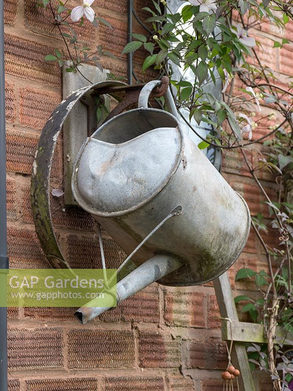 Old metal garden tools are used as rustic artwork.