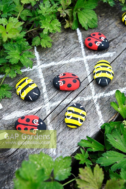 Garden craft making painted Bumble bees and Ladybirds with stones.  Draw a noughts and crosses board with chalk and use the painted insects as game pieces