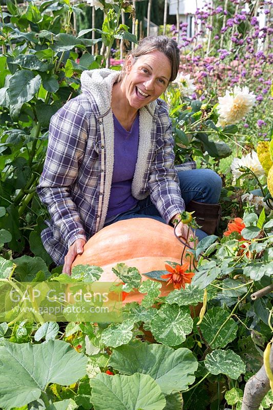 Woman admiring huge pumpkin in late Summer