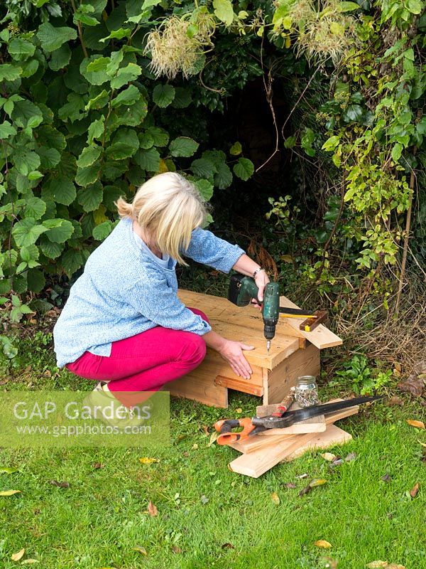 Construction of garden hedgehog house from recycled wood.