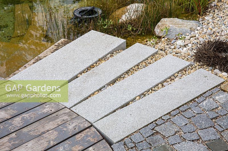 Circularly arranged granite blocks form a stair into the water