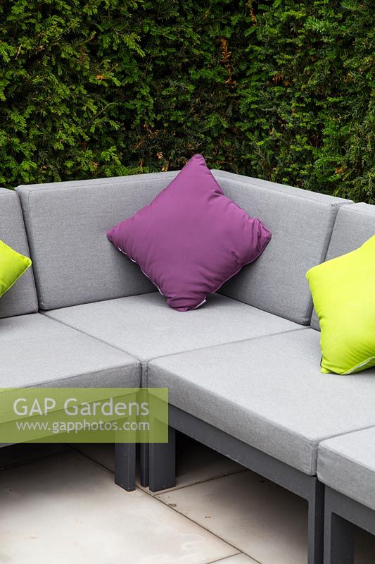 Corner sofa with colourful cushions in contemporary suburban garden