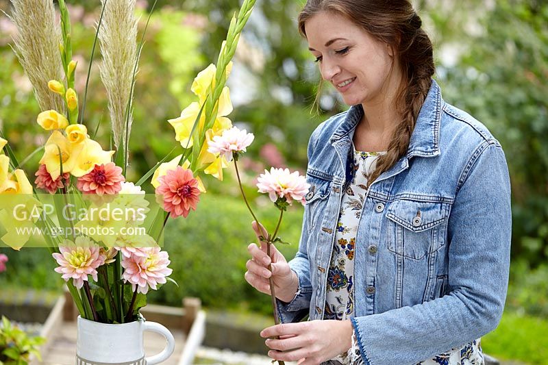 Woman creating Gladiolus and Dahlia bouquet