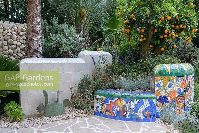 The Viking Cruises Garden of Inspiration - Mediterranean style planting with palms, succulents, Salvia, fruiting orange tree and mosaic covered wall inspired by Gaudi - RHS Chelsea Flower Show 2017 