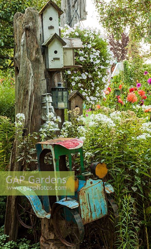 Bird houses in a tree with a bed of Phlox, Petunia and Dahlia 